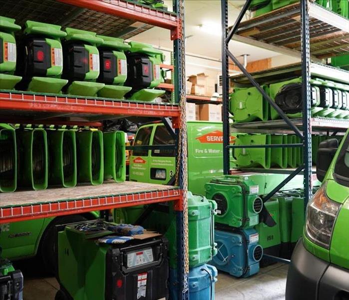 The garage, packed full of equipment such as driers and vans.