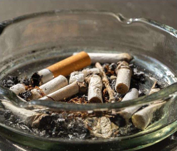 Cigarette butts in a home ashtray causing smoke odors  